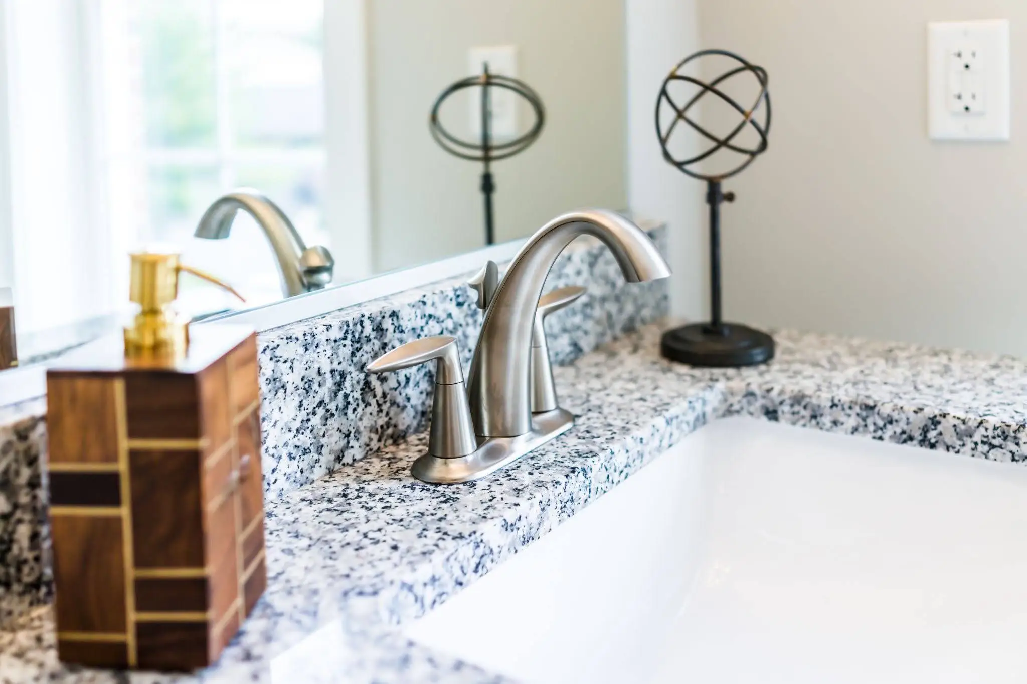 Polished granite bathroom countertop with an undermount sink and brushed nickel faucet