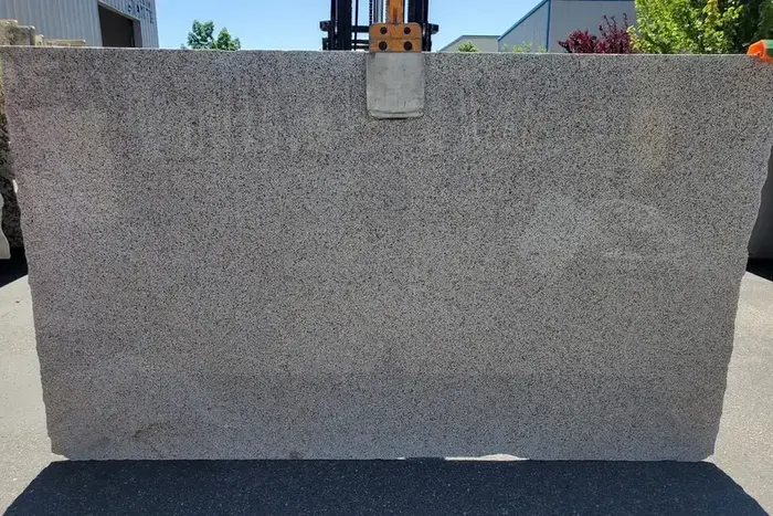 Giallo Fantasia polished granite slab displayed outdoors